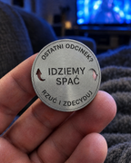 Moneta decyzyjna z grawerem Idziemy spać trzymana w dłoni