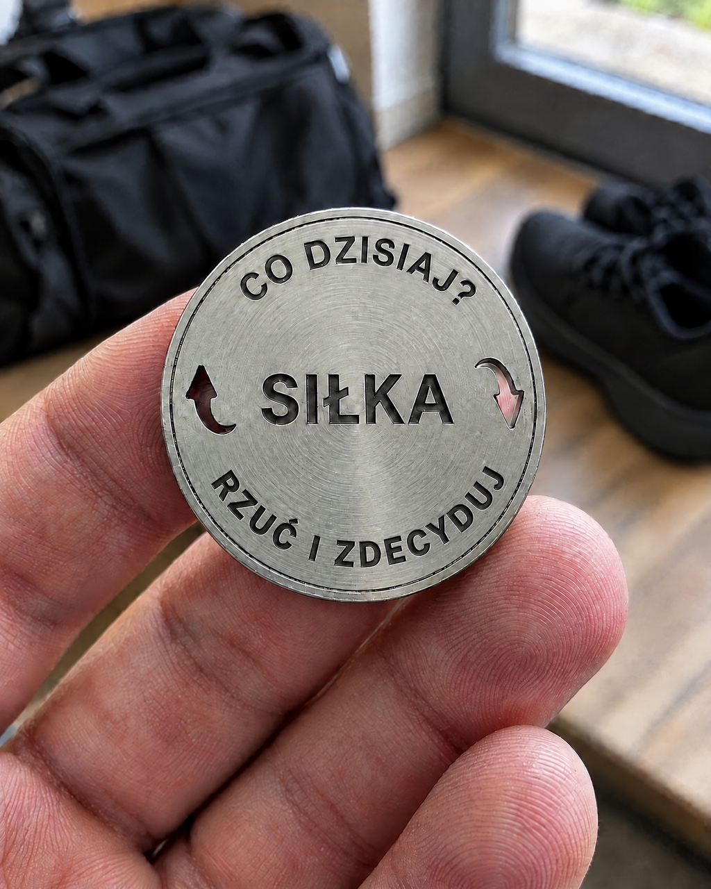 Moneta decyzyjna z grawerem Siłka trzymana w dłoni
