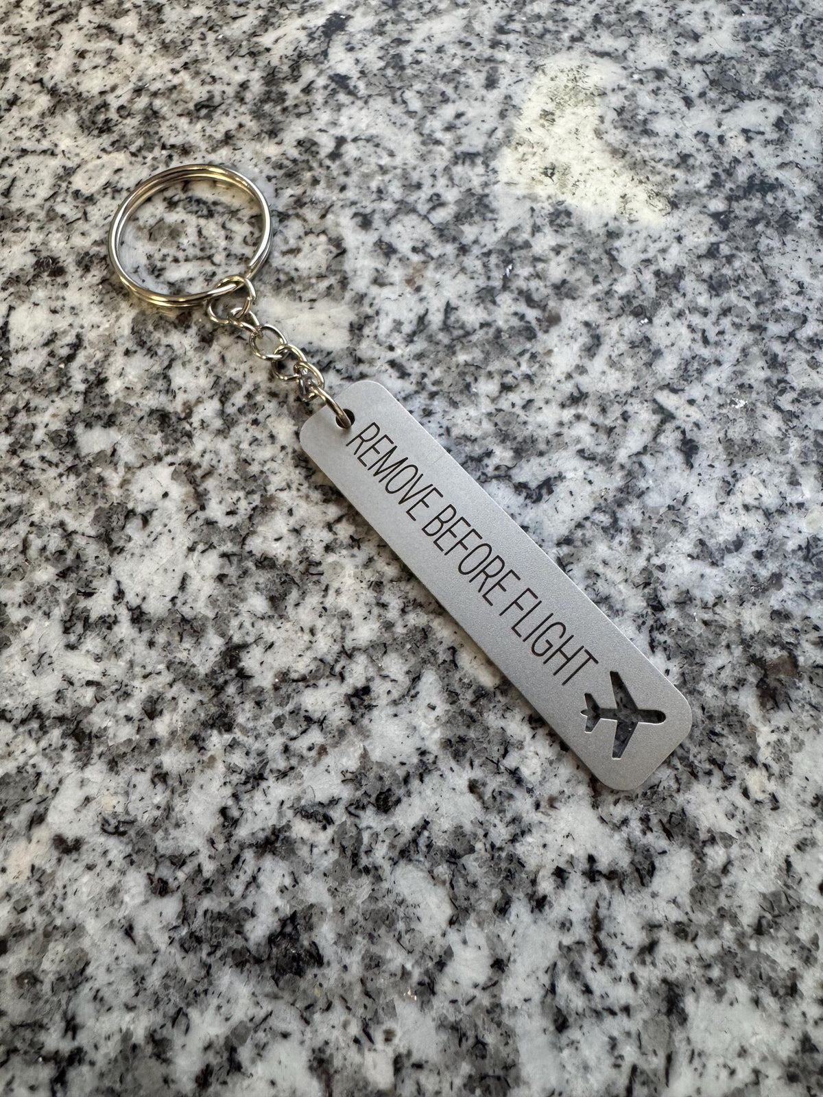 Metalowy breloczek Remove Before Flight, wykończenie matowe